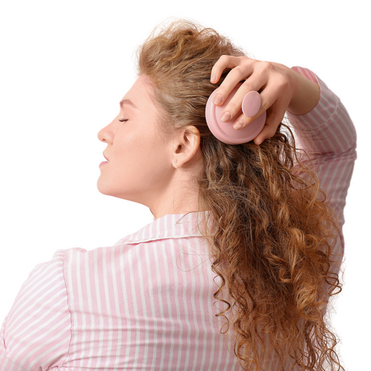 Haar massage borstel in haren van vrouw met rood krullend haar.